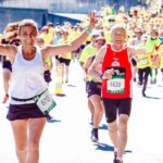 A group of diverse runners participating in a lively marathon event under the sun.